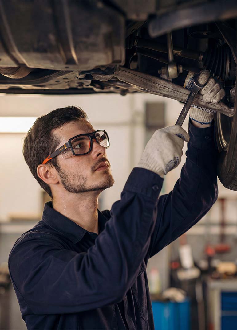 Man working as a mechanic while wearing safety glasses