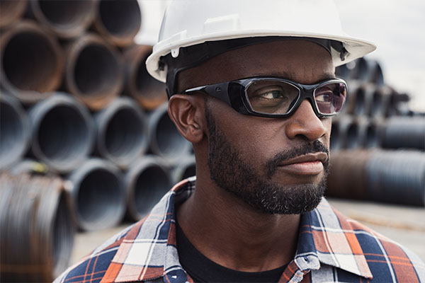two pairs of glasses on wood with contruction helmet